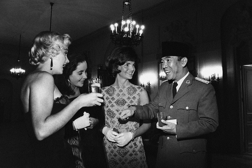 A black and white doctored photo shows former Indonesian President Sukarno with famous women. It is not real.