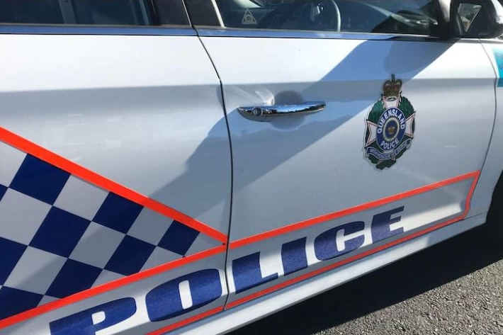 A white Queensland police vehicle fills the whole frame with the Queensland police logo on the side.