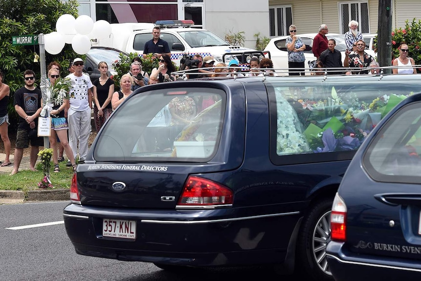 Hearse carrying one of the coffins of eight children drives by Murray Street in the suburb of Manoora