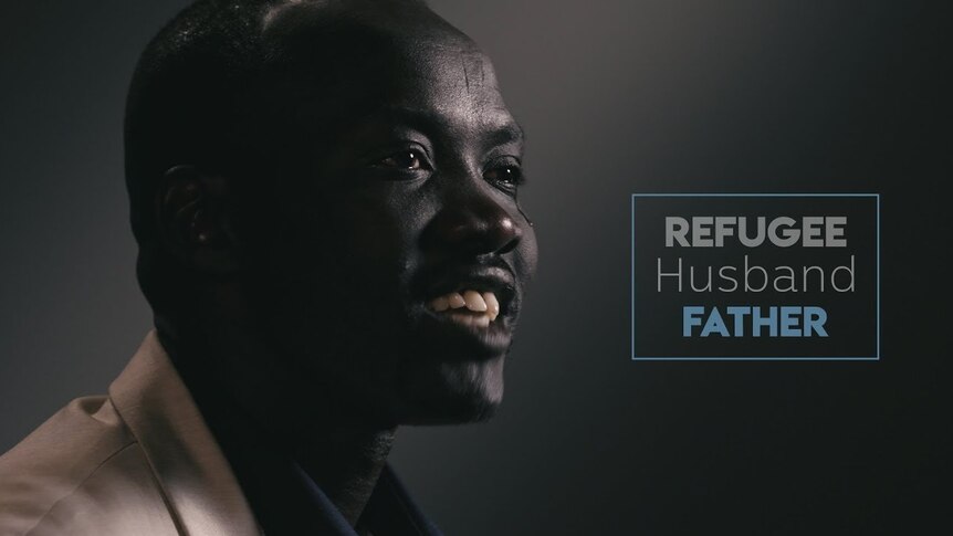 An African man talks, smiling, against background of a darkened photo studio.  Caption says 'Refugee, husband, father'.