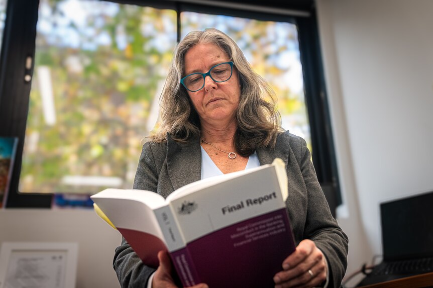 a woman reading the findings of the Hayne Royal Commission report