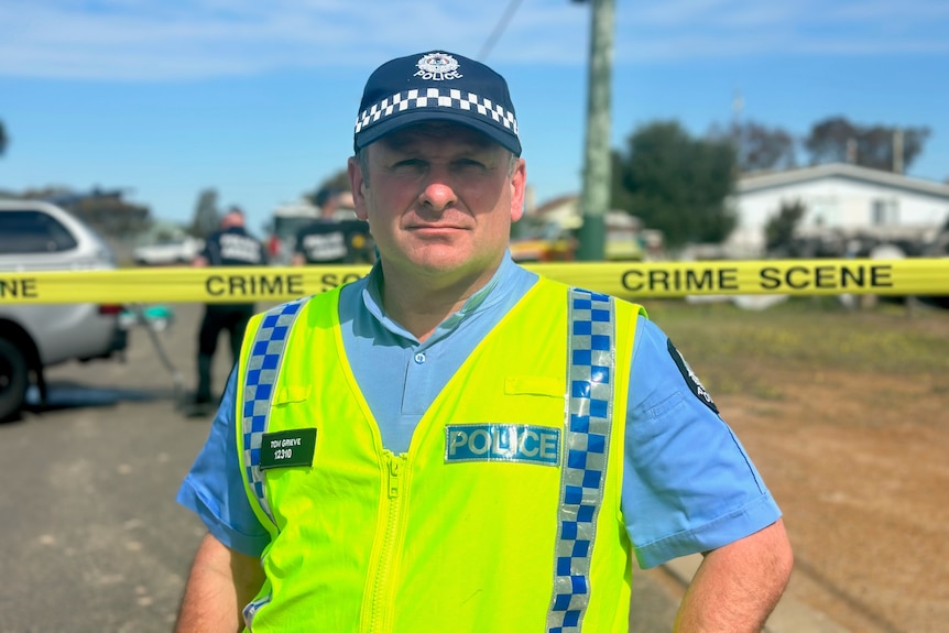 A police officer standing in front of a crime scene