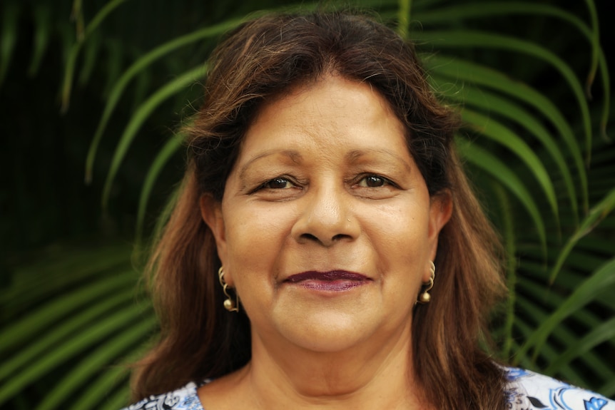 an aboriginal woman wearing a blue floral shirt