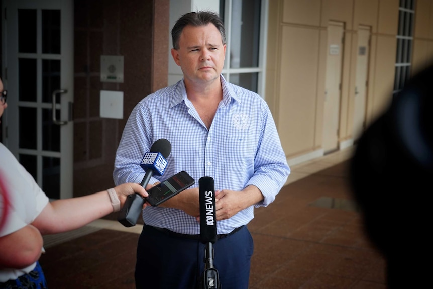 Paul McCue stands at a press conference