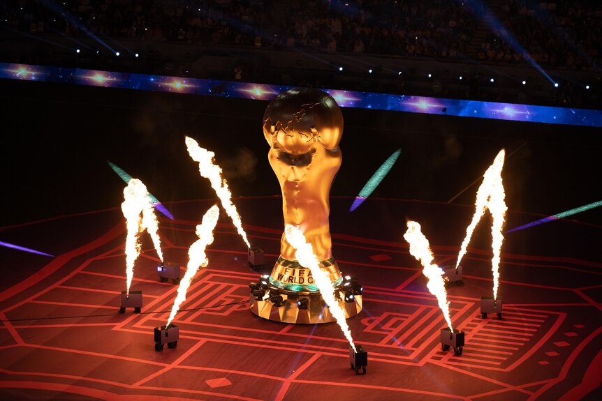 Flame throwers go off around a replica of the FIFA World Cup trophy.