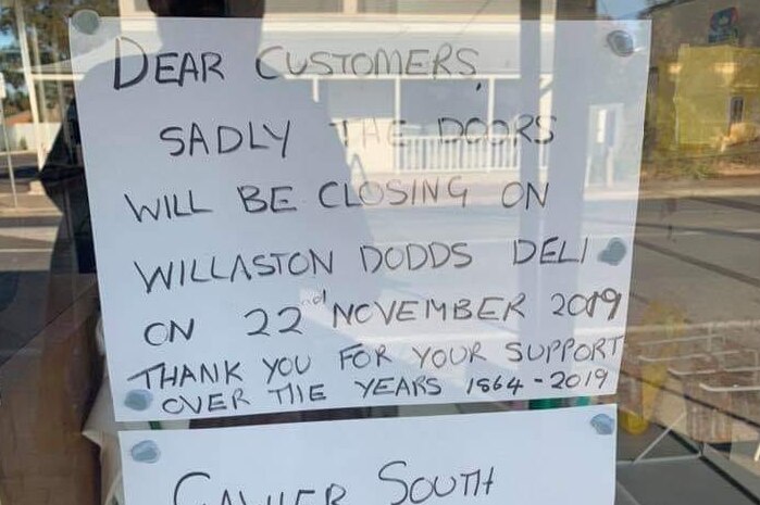 A sign on a shop door informing customers they are closing