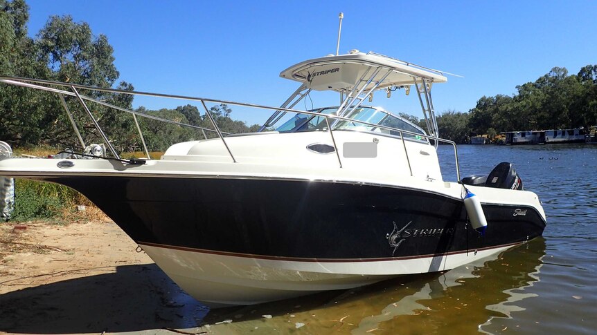 A cabin cruiser on the shore of a river.