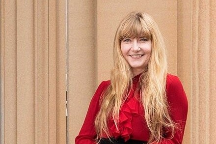 a woman with blonde hair and a red shirt smiling