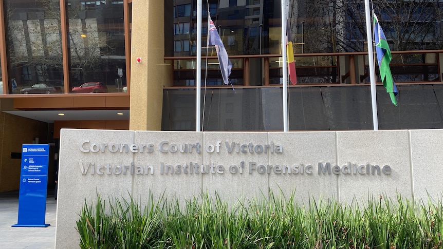The Coroners Court of Victoria sign in front of the Australian, Aboriginal, and Torres Strait Islander flags.
