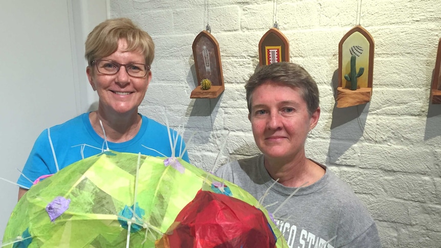 Adrienne Williams and Jenny Gilbertson stand with artworks from their exhibition at Gatakers Arts Space in Maryborough