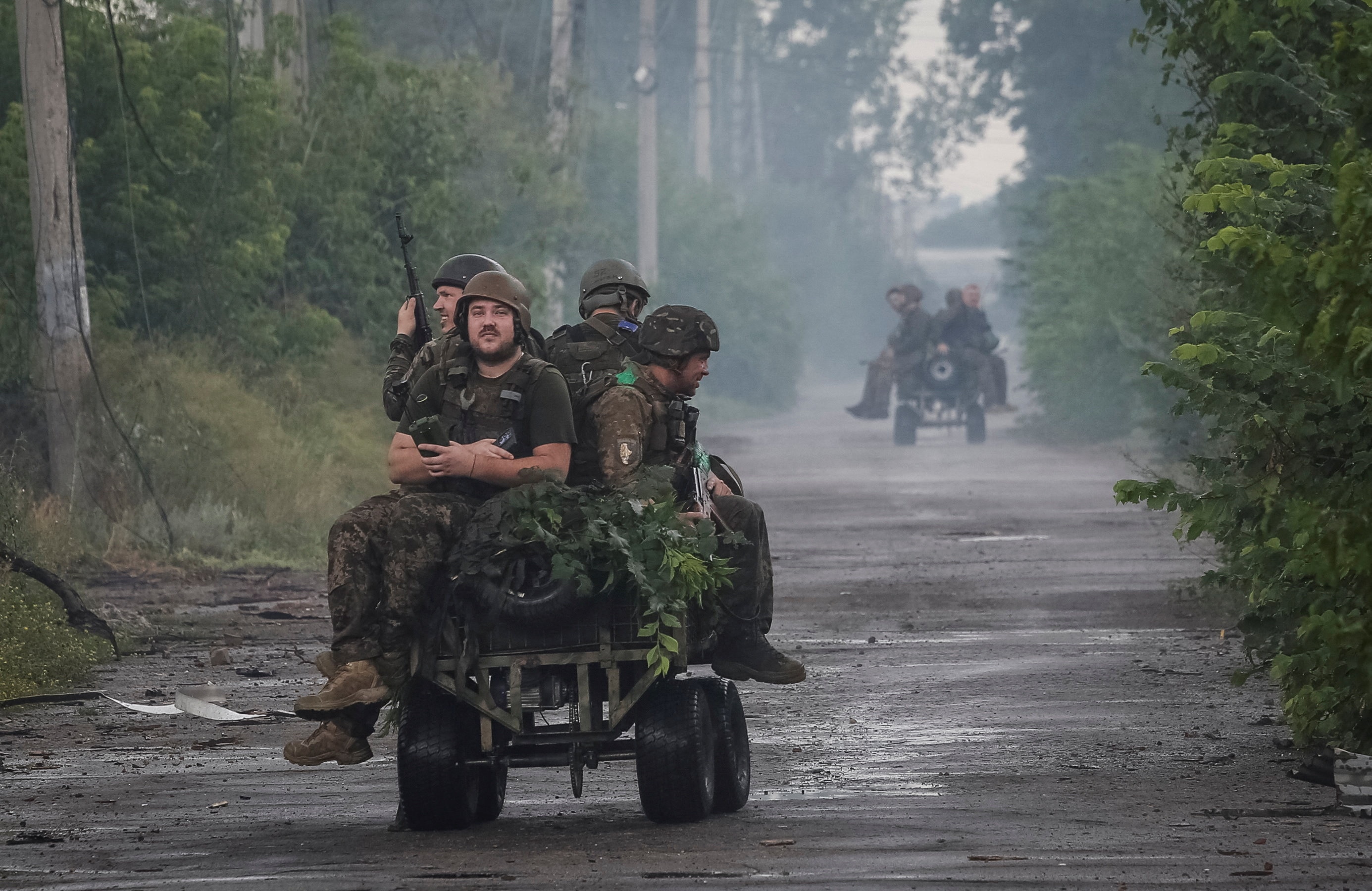 Ukrainian servicemen ride unmanned ground vehicles.