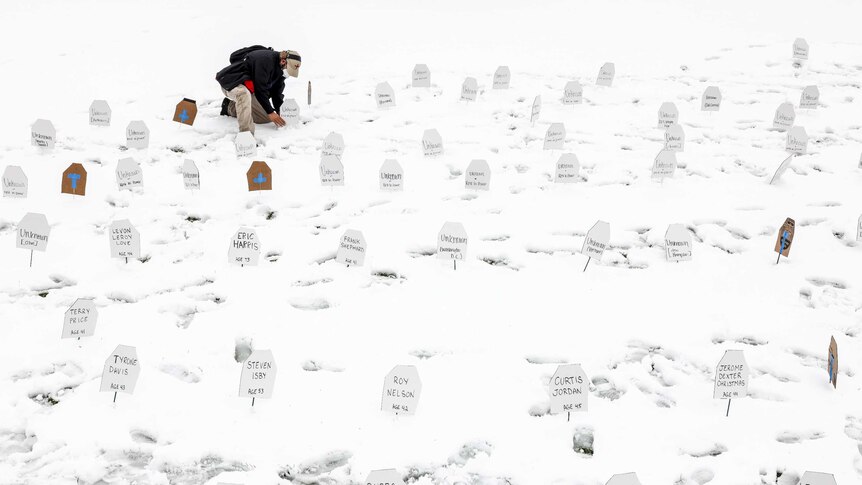 A man makes makeshift gravestones for victims of police violence in Denver, Colorado, April 2021