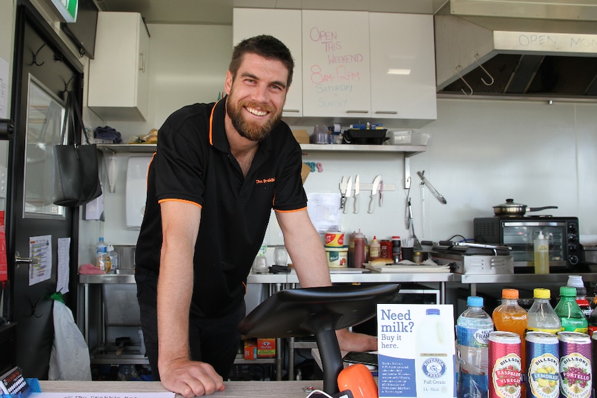 Owner of The Brekkie Box Dylan Connell standing behind the counter looking at the camera.