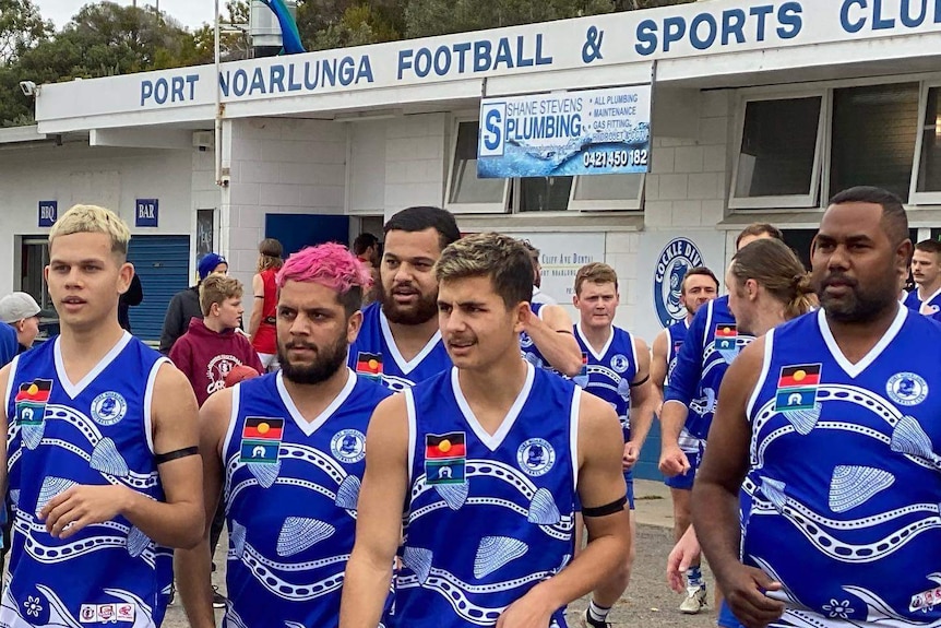 Port Noarlunga footballers take to the field in their club's Indigenous guernsey.