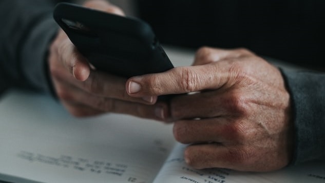 An unidentified man uses a phone.