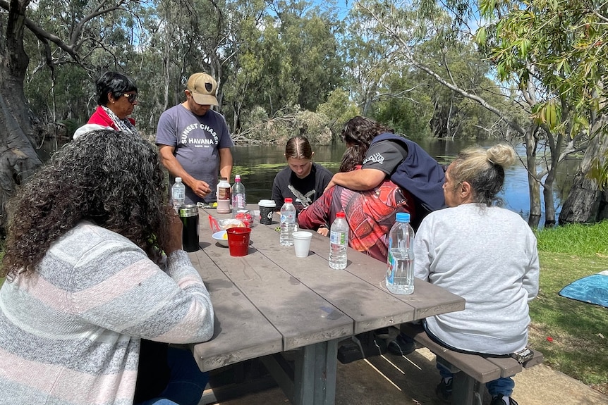 The family of 19-year-old Nungarra Kelly pictured on the edge of the Murrumbidgee River sitting around a picnic table