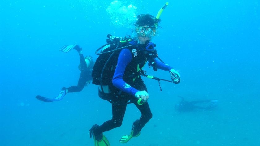 An unsuspecting diver poses for a photo while Tina Watson lies dying on the ocean floor.