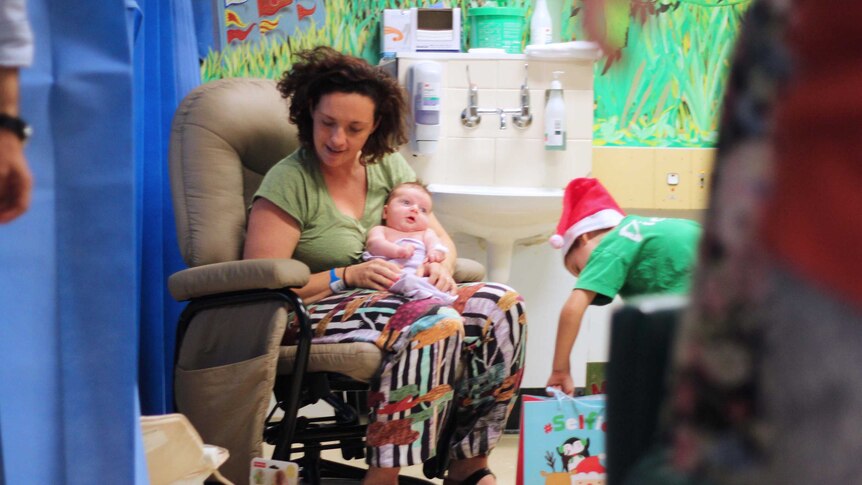 children hand out presents at a hospital