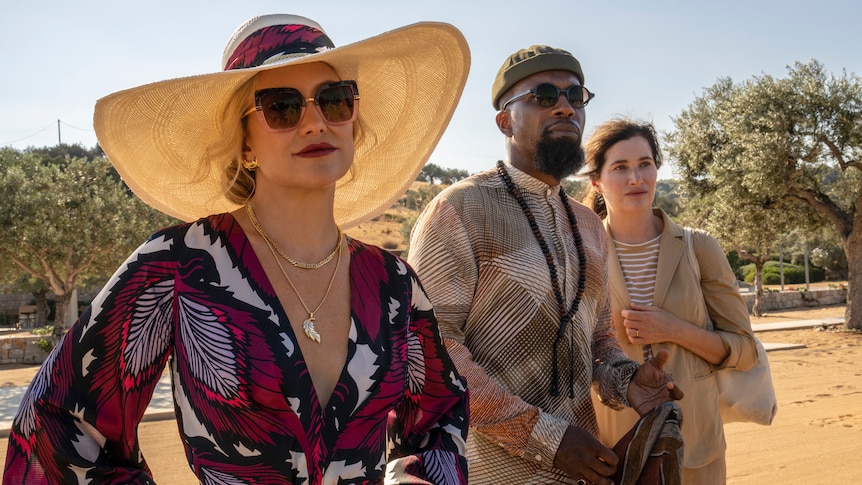 A film still of Kate Hudson in sunglasses and a luxurious wide brim hat.