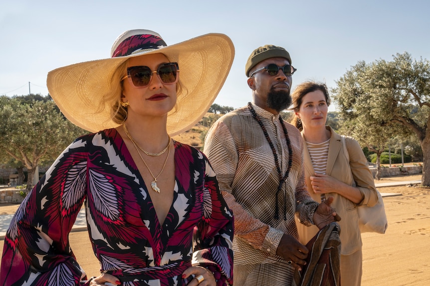 A film still of Kate Hudson in sunglasses and a luxurious wide brim hat.