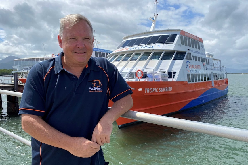 A man smiles next to a boat.