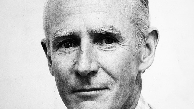 A black and white photo of a man wearing a shirt and a tie.