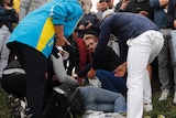 Brooks Koepka offers a golf glove to a spectator he injured with his drive at the 2018 Ryder Cup.