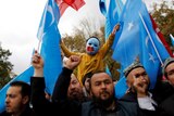A masked Uyghur boy takes part in a protest against China, at Fatih Mosque in Turkey