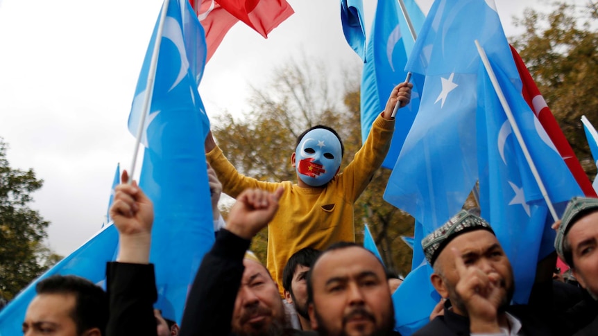 A masked Uyghur boy takes part in a protest against China, at Fatih Mosque in Turkey