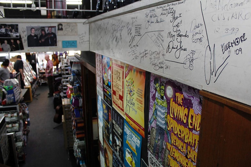 Autographs on a wall in a music store.