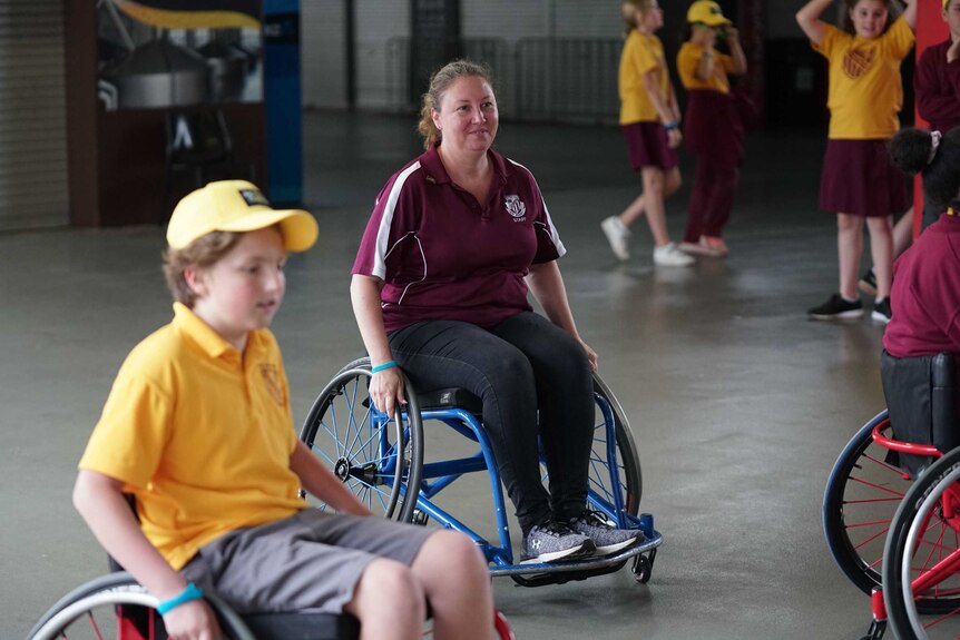 Tilda Brownlow's teacher, Natasha Martin, joins her student in experiencing a game of wheelchair basketball.