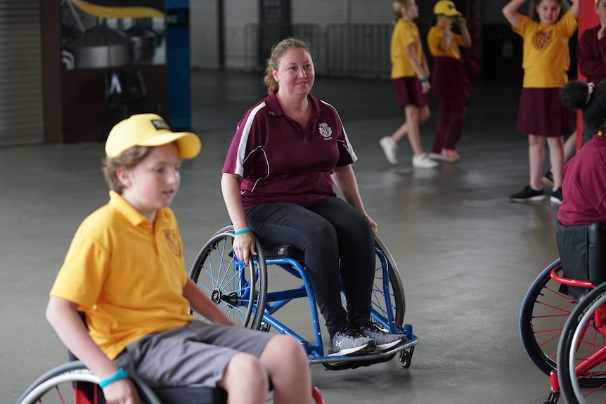 Tilda Brownlow's teacher, Natasha Martin, joins her student in experiencing a game of wheelchair basketball.