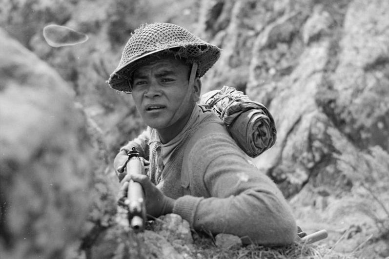 A Gurkha of 4th Indian Division keeps watch on enemy positions in Alpi di Catenaia from high ground on Monte Castiglione, 29 July 1944.