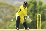 A batter wearing Western Australian colours eyes the ball as he steps forward to hit it.