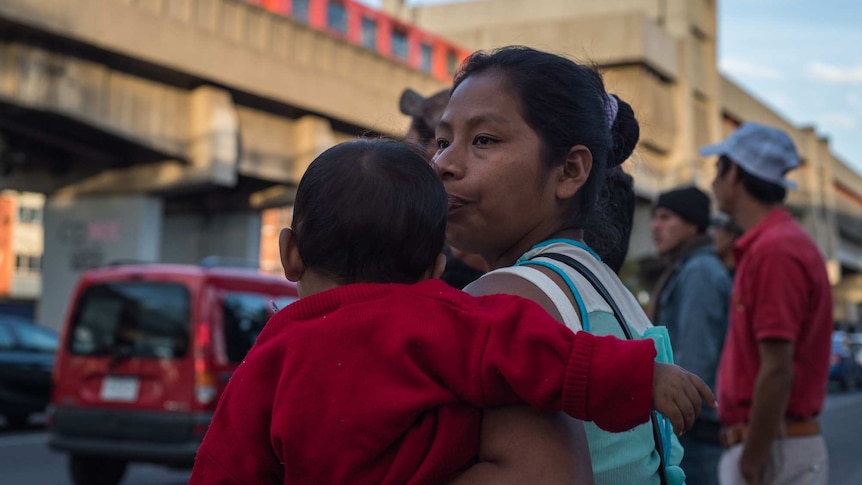 The back of a woman holding a baby