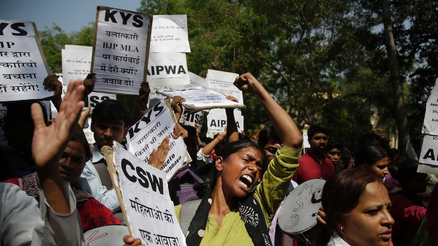 A women screams in the middle of a crowd of protesters