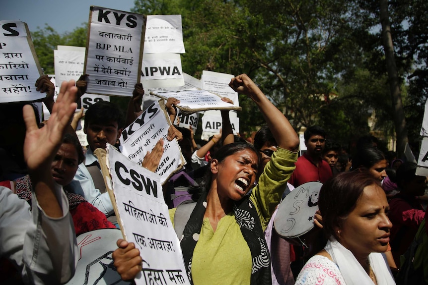 A women screams in the middle of a crowd of protesters