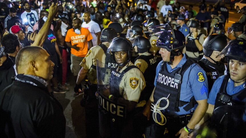 St Louis County police officers with anti-police demonstrators during protests in Ferguson, Missouri