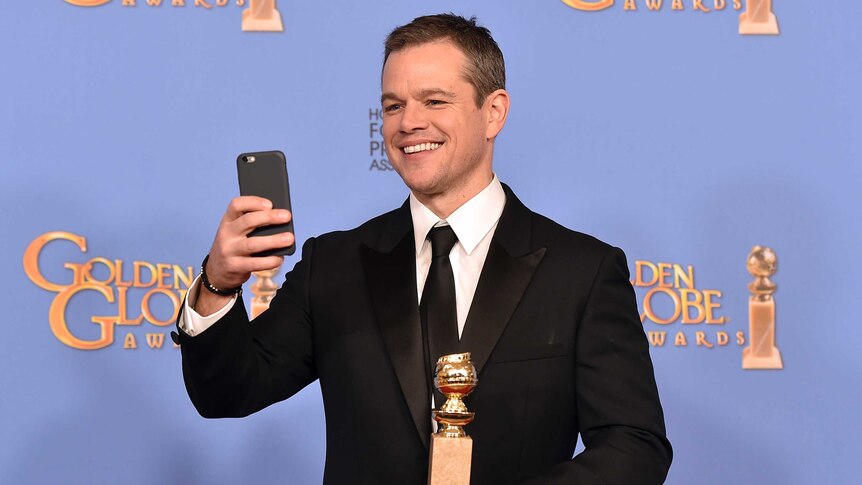 Matt Damon with his Golden Globe Award for The Martian