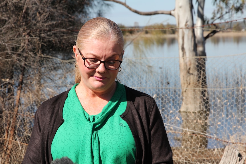 Michelle Vearing looking down at the ground in front of Lake Wyangan, Griffith.