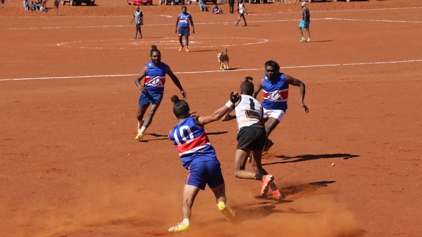 The Fregon Bulldogs players on a red dirt oval.