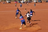The Fregon Bulldogs players on a red dirt oval.
