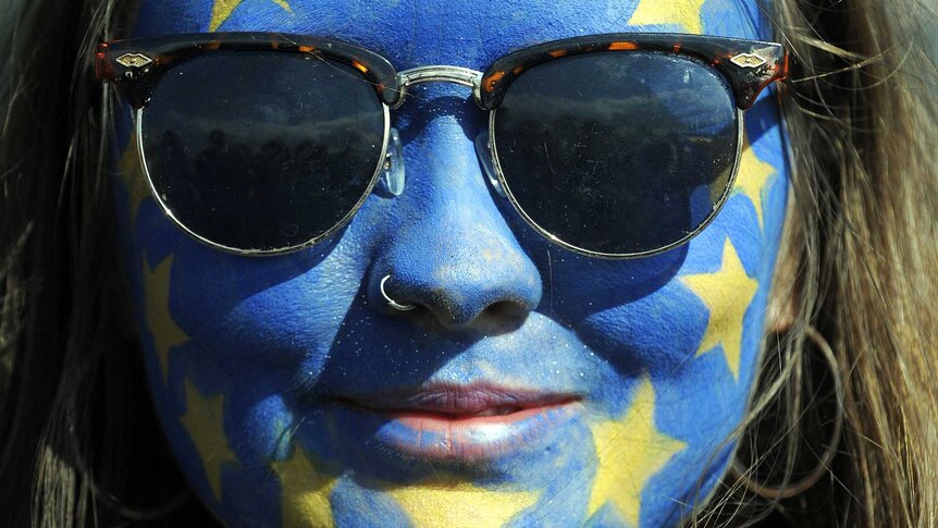 A festival-goer with a European flag painted on her face poses for a photograph on day three of the Glastonbury Festival