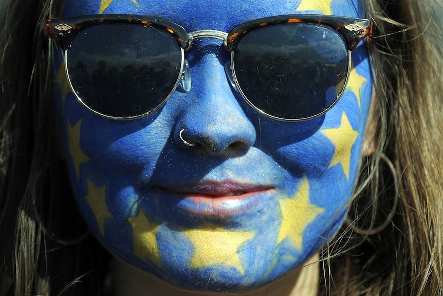 A festival-goer with a European flag painted on her face poses for a photograph on day three of the Glastonbury Festival