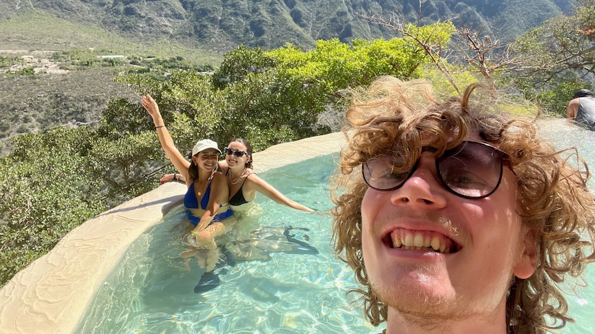 Tallis takes a selfie in an outdoor mountain pool with two friends.