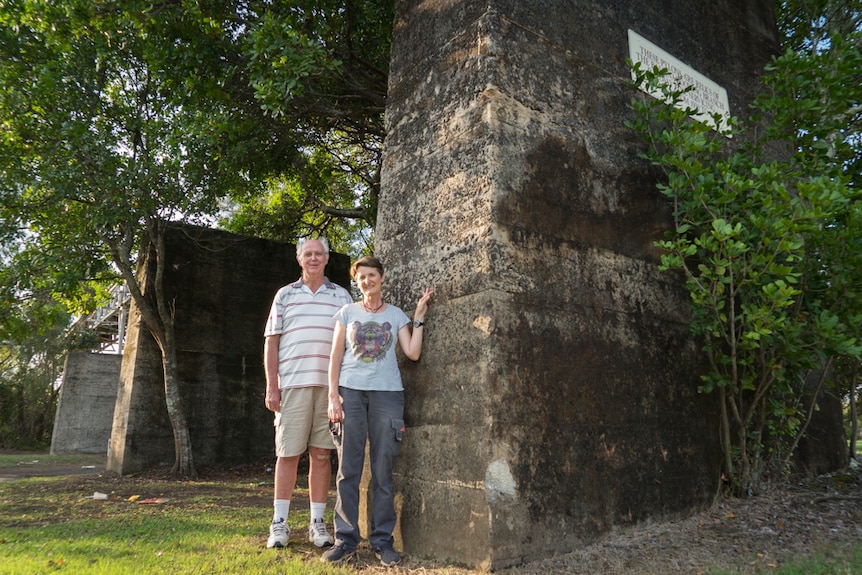 A man and a woman stand in front of brick pylons with a plaque stating the pylons are relics of the Ballina Railway bridge.