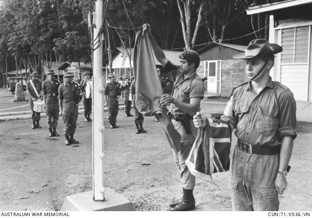 Soldiers in Vietnam lower the Australian flag.