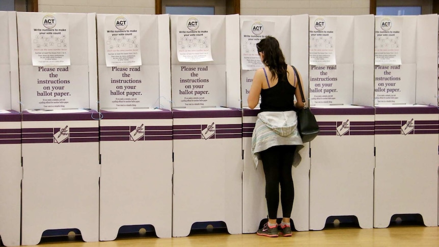 A person voting at a booth in the ACT election