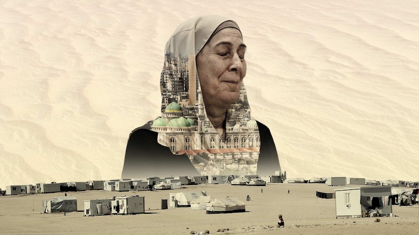 You view a woman in a hijab with closed eyes looking over a sparse refugee camp in the desert.