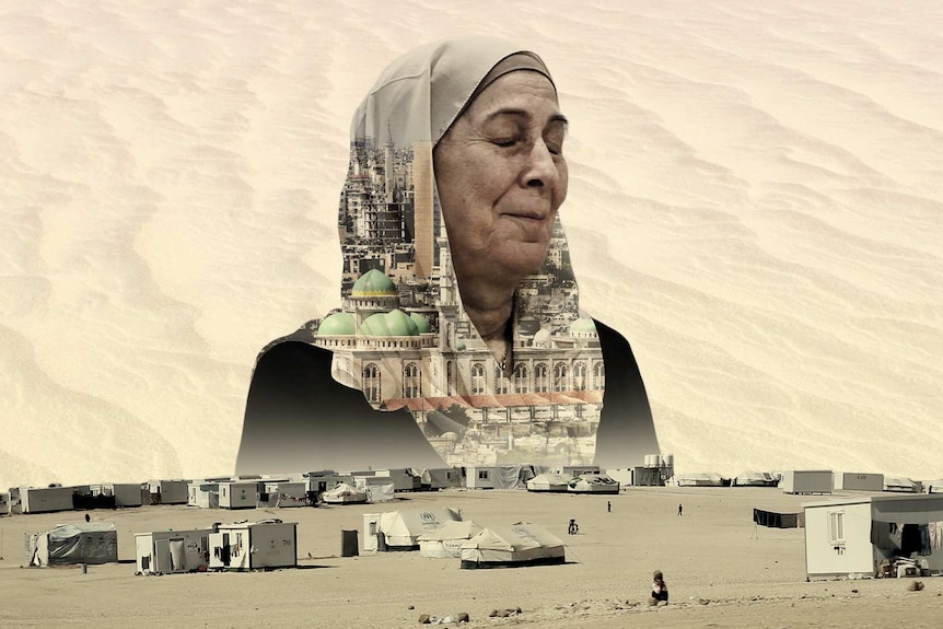 You view a woman in a hijab with closed eyes looking over a sparse refugee camp in the desert.